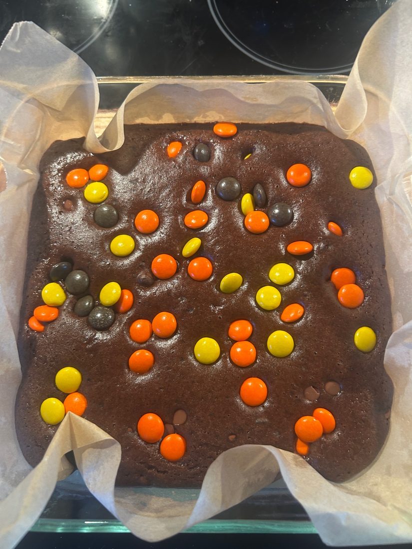 Bean brownies mid-bake with Reese's Pieces scattered on top