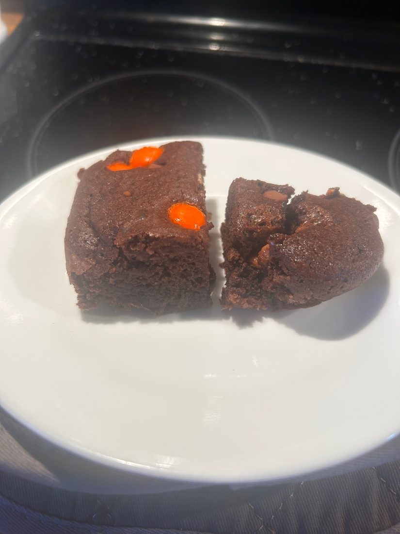 Two bean brownies on a plate showing the gooey centres